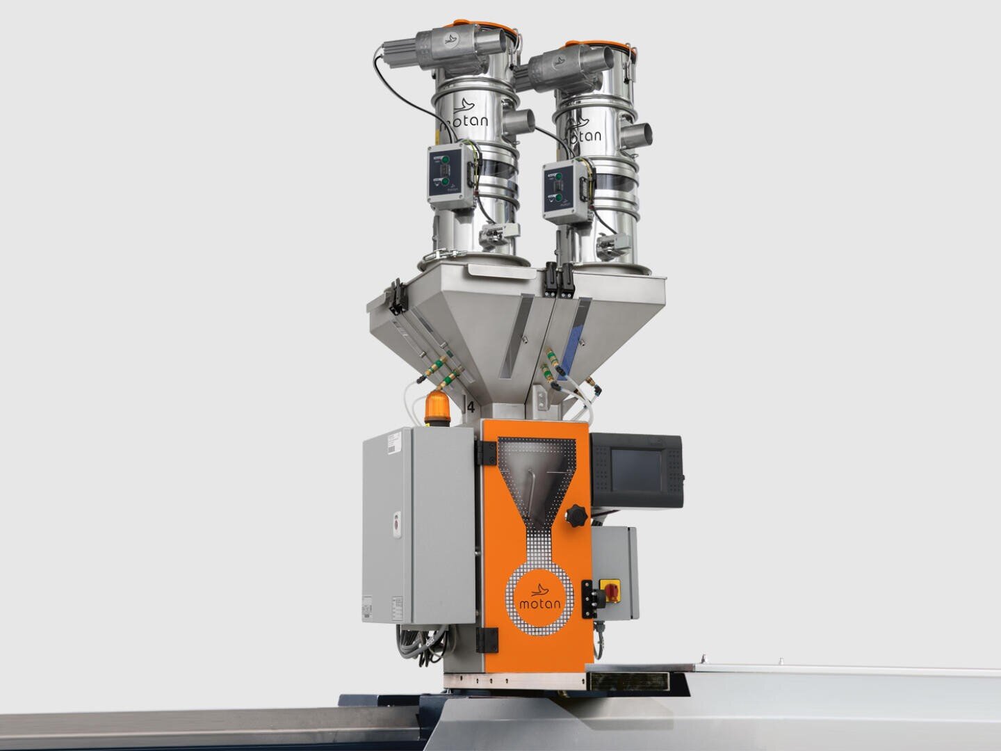 Une machine industrielle moderne avec deux trémies en acier inoxydable, des affichages numériques et un panneau de commande orange, utilisée pour le traitement ou le mélange de matériaux dans un environnement d'usine.