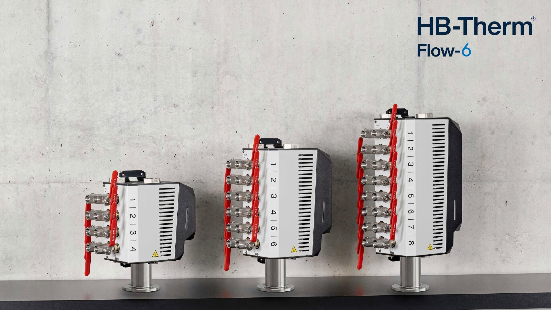 Drei HB-Therm Flow-6-Geräte unterschiedlicher Größe stehen auf einer dunklen Fläche vor einer Betonwand in einer Reihe. Jedes Gerät verfügt über nummerierte vertikale Anzeigen und rote Hebel; das Logo und der Produktname sind in der oberen rechten Ecke zu sehen.