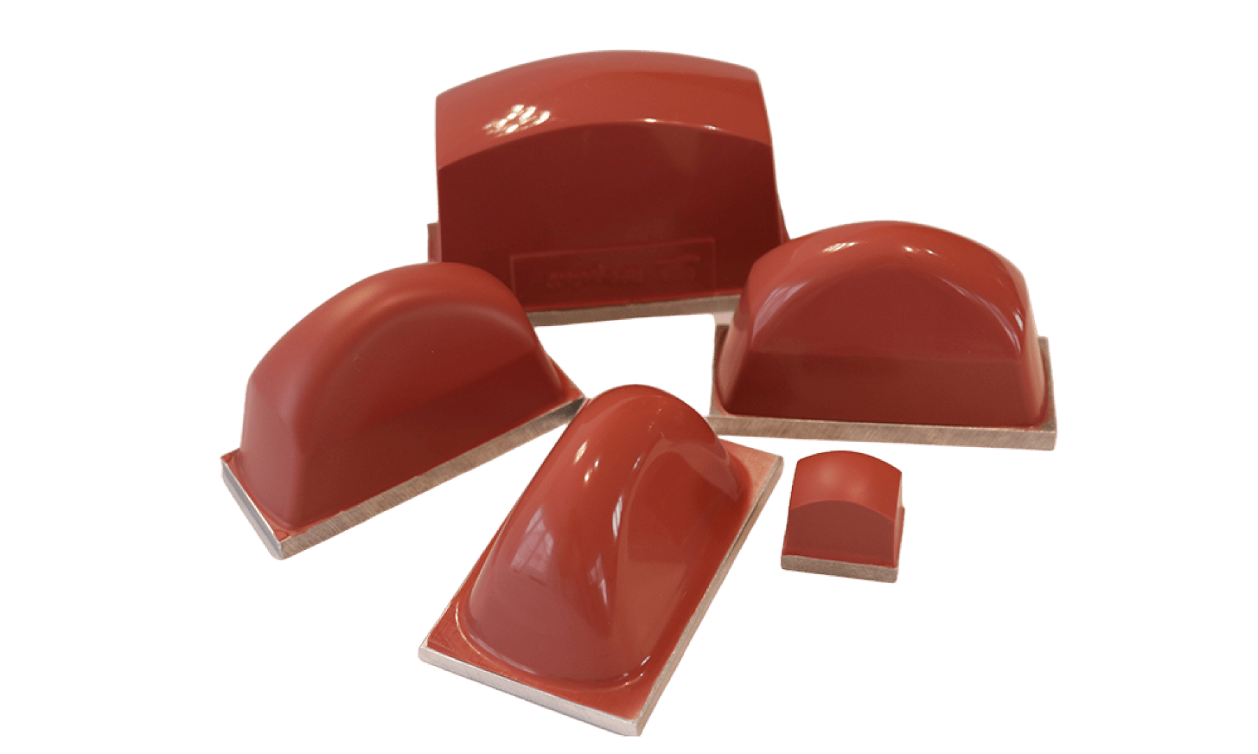 Cinq moules en silicone rouges, lisses, en forme de dôme et de tailles différentes sont présentés sur une surface blanche. Chaque moule est monté sur une base rectangulaire en bois ou en plastique.