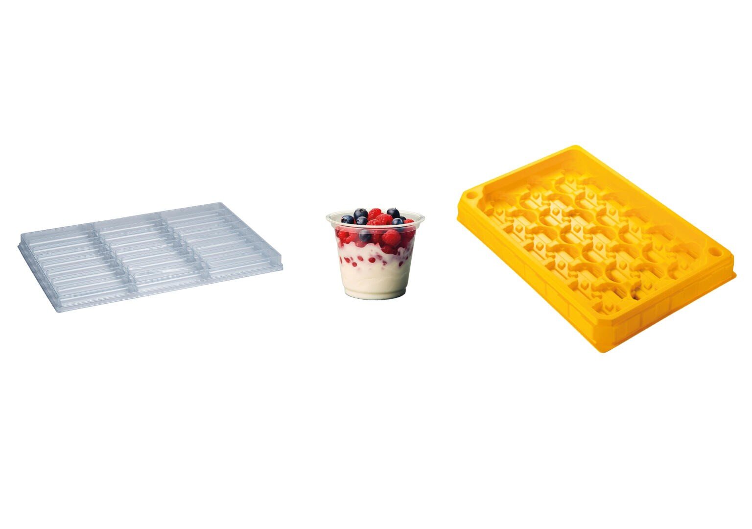 Eine durchsichtige Schokoladenform, ein Joghurtbecher mit Früchten und eine gelbe Silikonform sind nebeneinander auf einem weißen Hintergrund abgebildet.