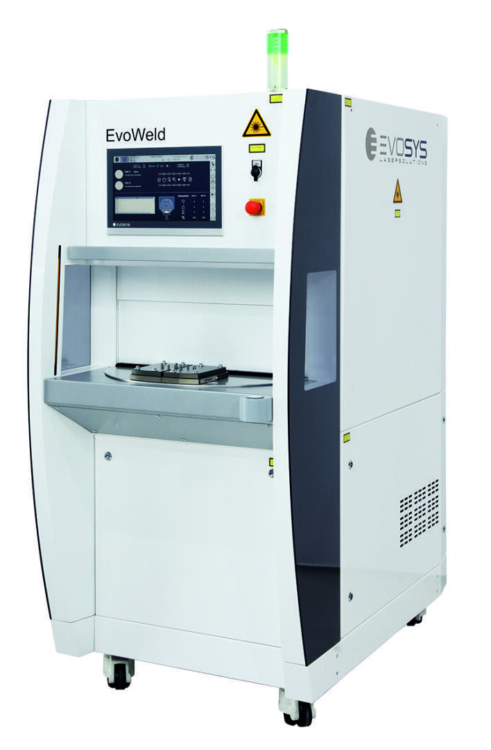 Eine weiße Industriemaschine mit der Aufschrift EvoWeld mit Bedienfeld, Tasten und einem Bildschirm auf der Vorderseite, hergestellt von EVOSYS. Sie hat einen Arbeitsbereich mit einer drehbaren Plattform und einer grünen Anzeigeleuchte oben.