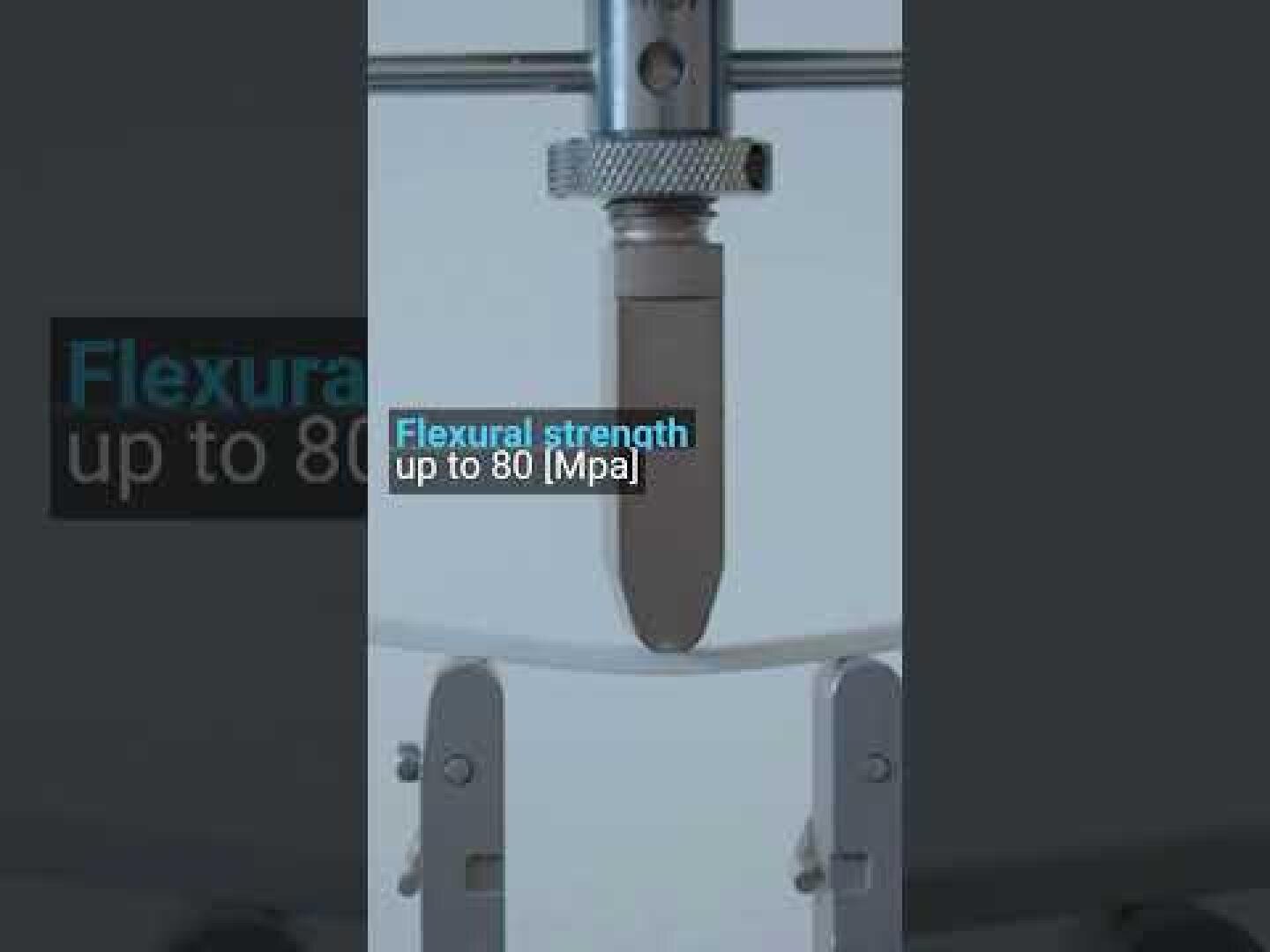 Nahaufnahme einer Maschine zur Prüfung der Biegefestigkeit an einem Probestab, mit Textüberlagerung: Biegefestigkeit bis zu 80 MPa.