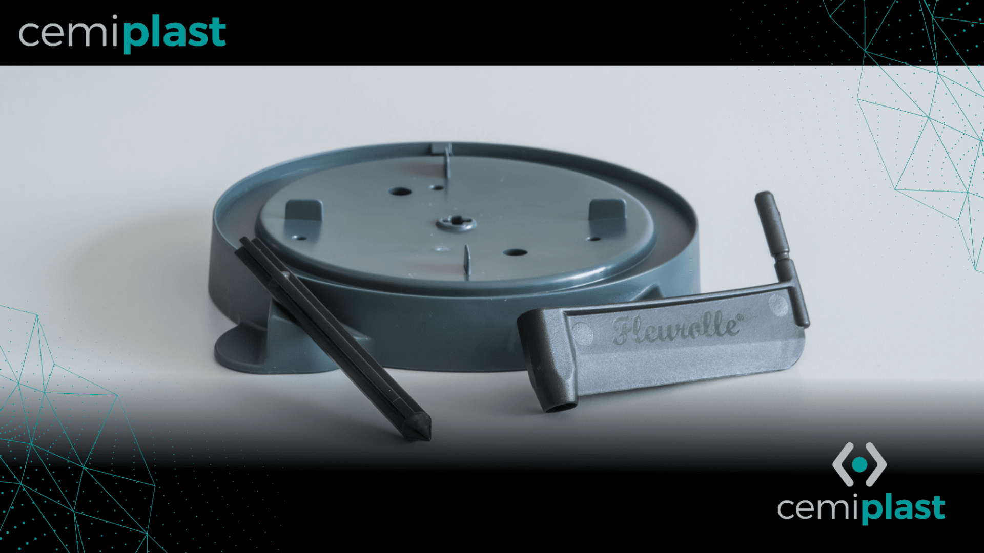 Une base ronde en plastique gris, accompagnée de deux pièces en plastique noir, repose sur une surface blanche. Le mot Heanelle est gravé en relief sur l'une des pièces. L'image comporte la marque cemiplast dans les coins.