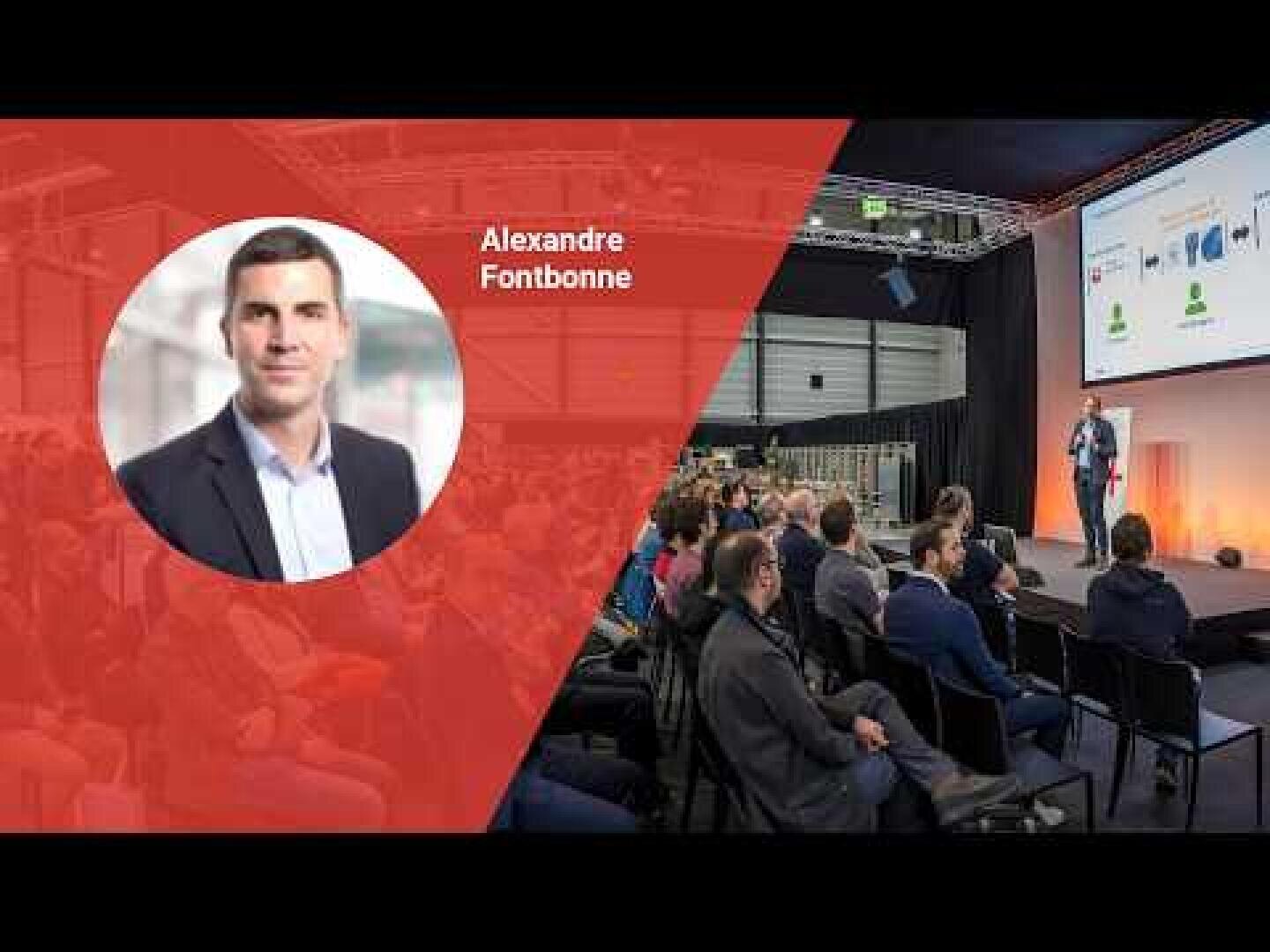 Un public nombreux regarde un homme faire une présentation sur scène ; une incrustation rouge sur la gauche présente un portrait d'un homme appelé Alexandre Fontbonne.