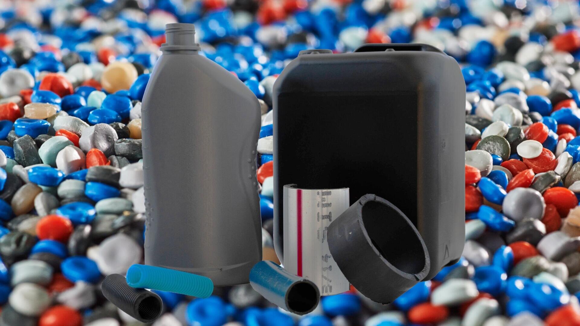 Sur un fond flou de granulés de plastique colorés, différents récipients et pièces en plastique sont présentés pour illustrer le recyclage ou la fabrication de plastique.