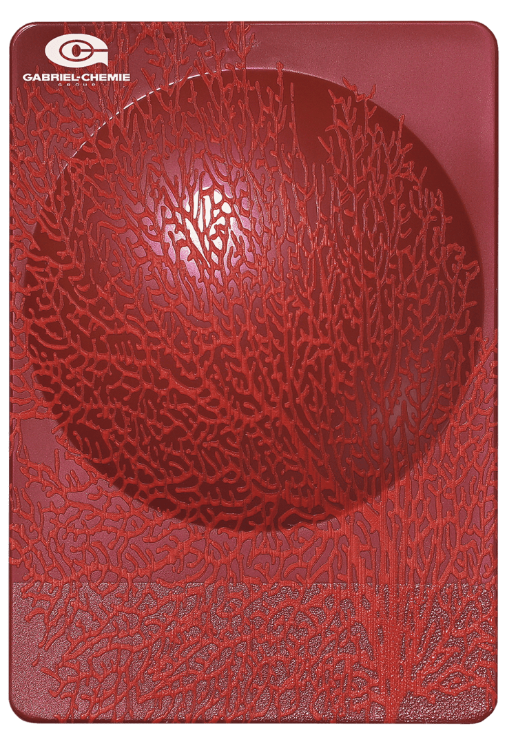 Ein rotes, strukturiertes Kunststoffmuster mit einem korallenähnlichen, erhabenen Muster und einer kreisförmigen Vertiefung, mit dem Gabriel-Chemie-Logo in der linken oberen Ecke.