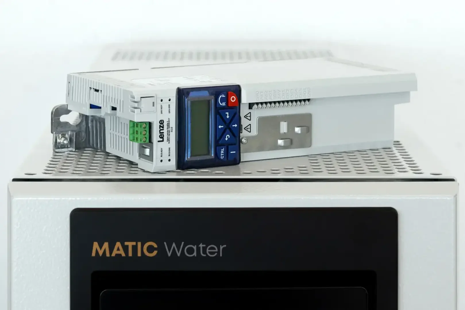 Nahaufnahme eines elektronischen Geräts mit Tasten und einem Bildschirm, das auf einem grauen Gerät mit der Aufschrift MATIC Water steht. Das Gerät hat Anschlüsse und eine Halterung.