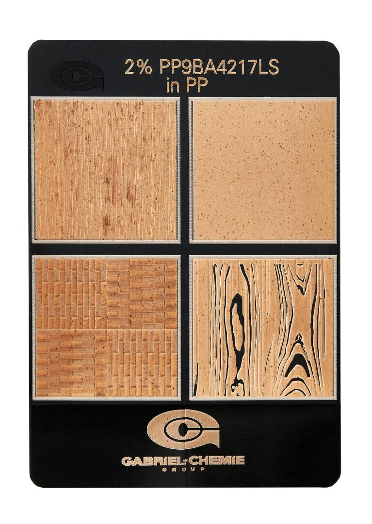 Eine Musterkarte zeigt vier beigefarbene Kunststofftexturen mit unterschiedlichen holzähnlichen Mustern, die oben mit 2% PP9BA4217LS in PP und unten mit dem Firmenlogo der Gabriel Chemie Group beschriftet sind.