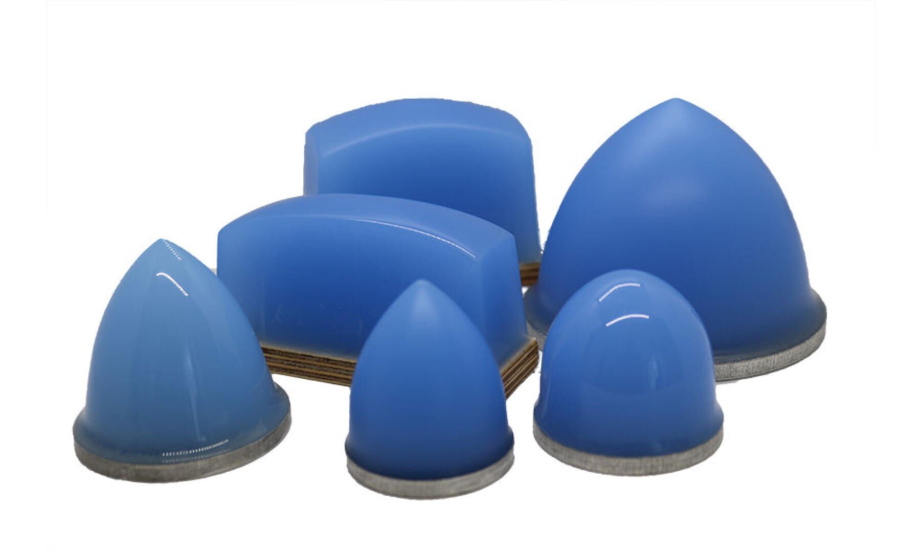 Six éponges de polissage en silicone bleues, en forme de dôme, de tailles différentes, certaines avec une base plate, d'autres avec des pointes arrondies, sont disposées sur un fond blanc.