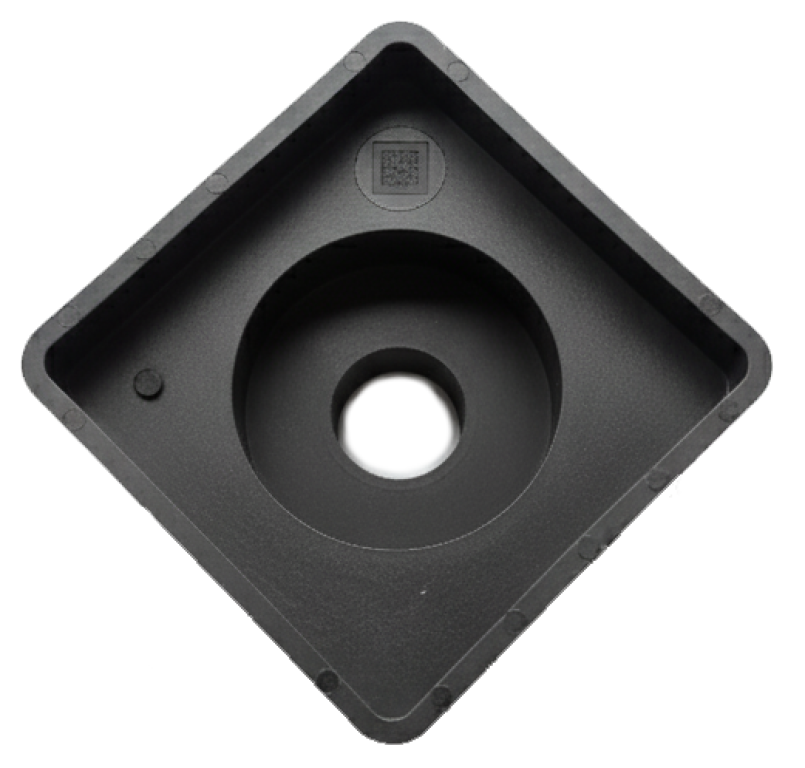 Schwarzes, quadratisches Kunststofftablett mit einer kreisförmigen Vertiefung und einem Loch in der Mitte, von oben gesehen vor einem hellgrauen Hintergrund.